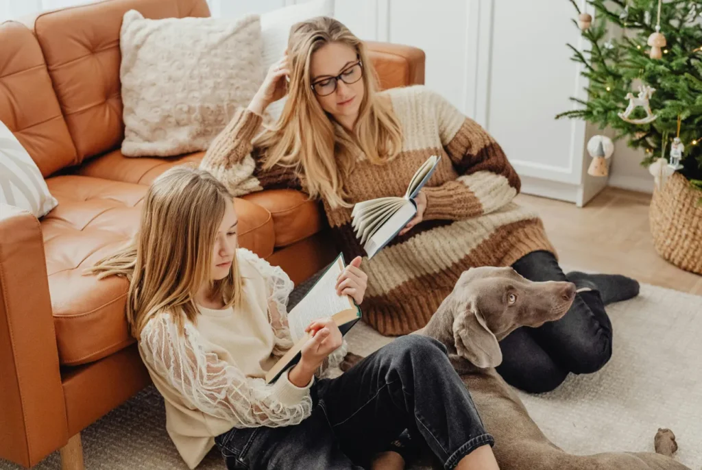 Mother and her daughter reading comfortably inside their home
